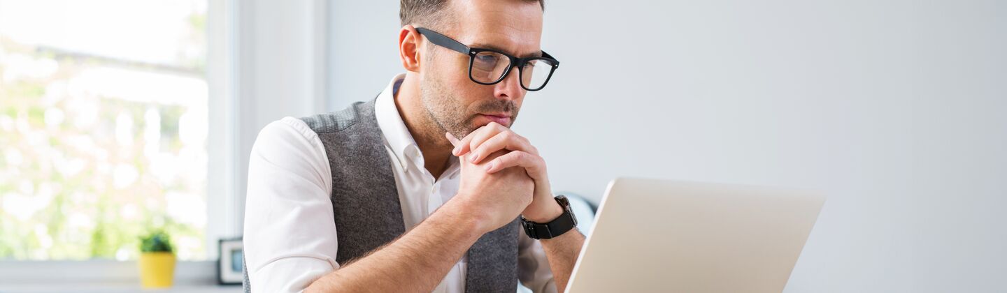COLOUR-IMAGE_Man_glasses_working_laptop_home_july26