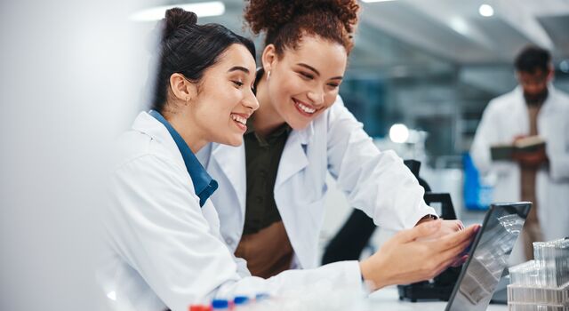 COLOUR-IMAGE_life-science-female-lab-technician-smiling-at-laptop_jun26