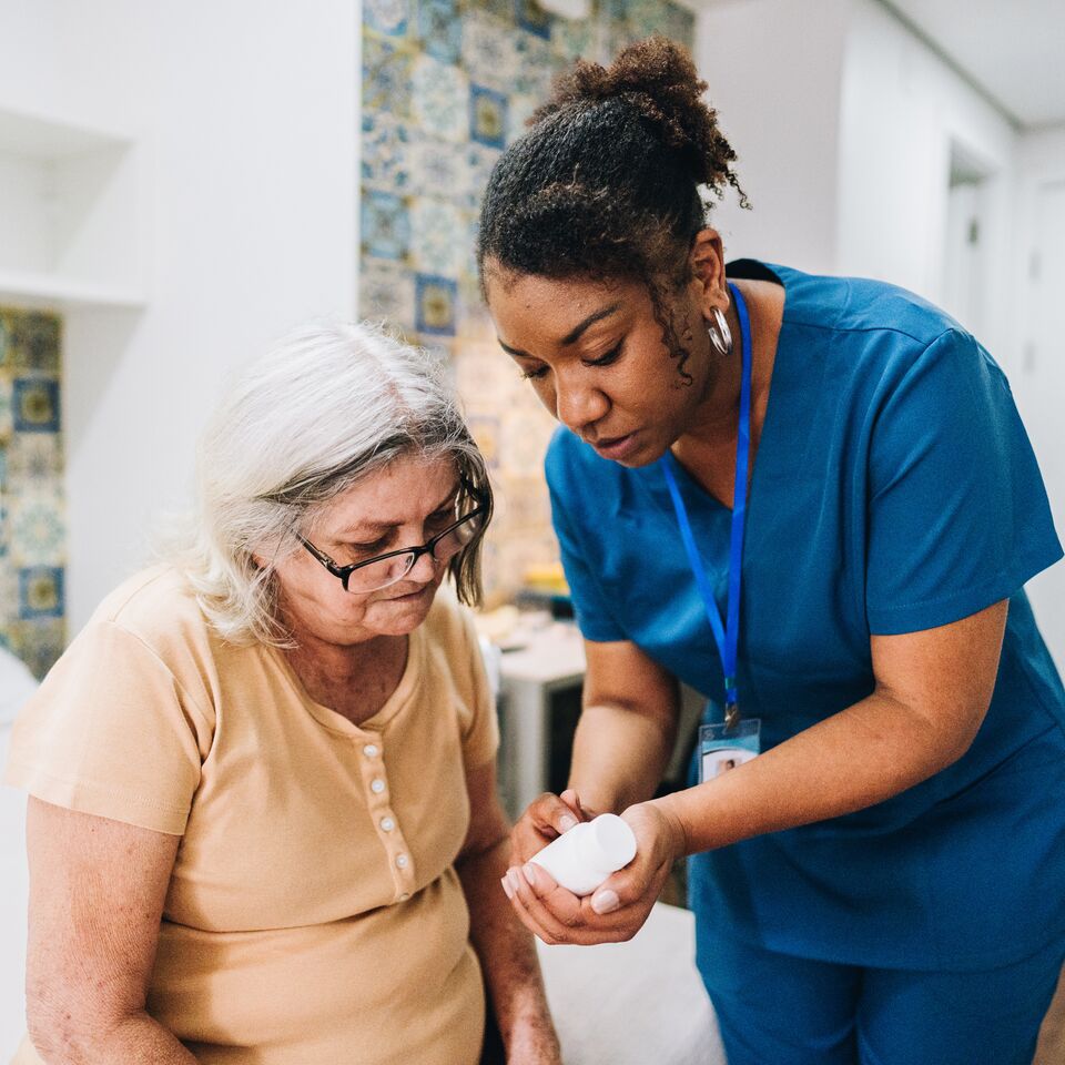 COLOUR-IMAGE_black-female-nurse-showing-elderly-patient-medication_apr26