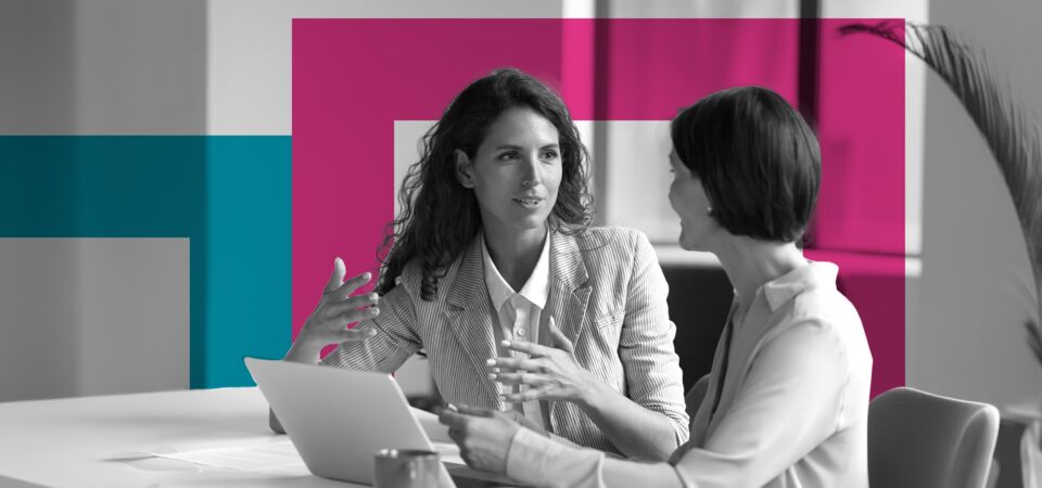 SINGLE-IMAGE_squares-two-business-women-sit-at-desk-laptop_may24