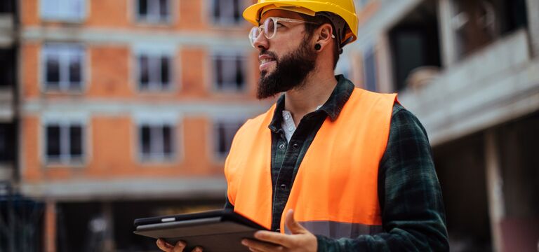 COLOUR-IMAGE_construction-worker-standing-tablet_july26