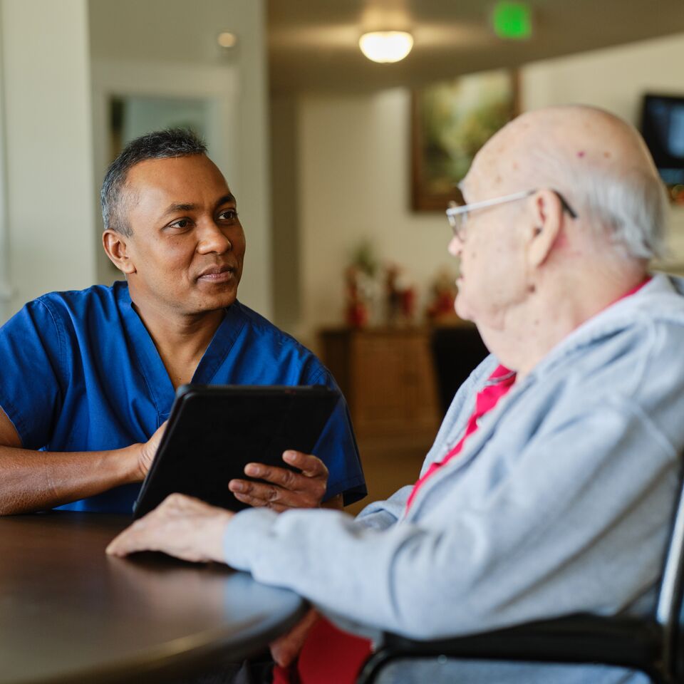 COLOUR-IMAGE_older-male-nurse-speaking-with-elderly-patient_apr26