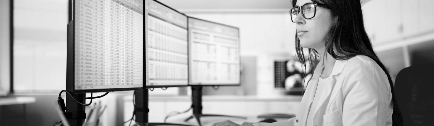 SINGLE-IMAGE_woman-at-computer-triple-monitors_aug25