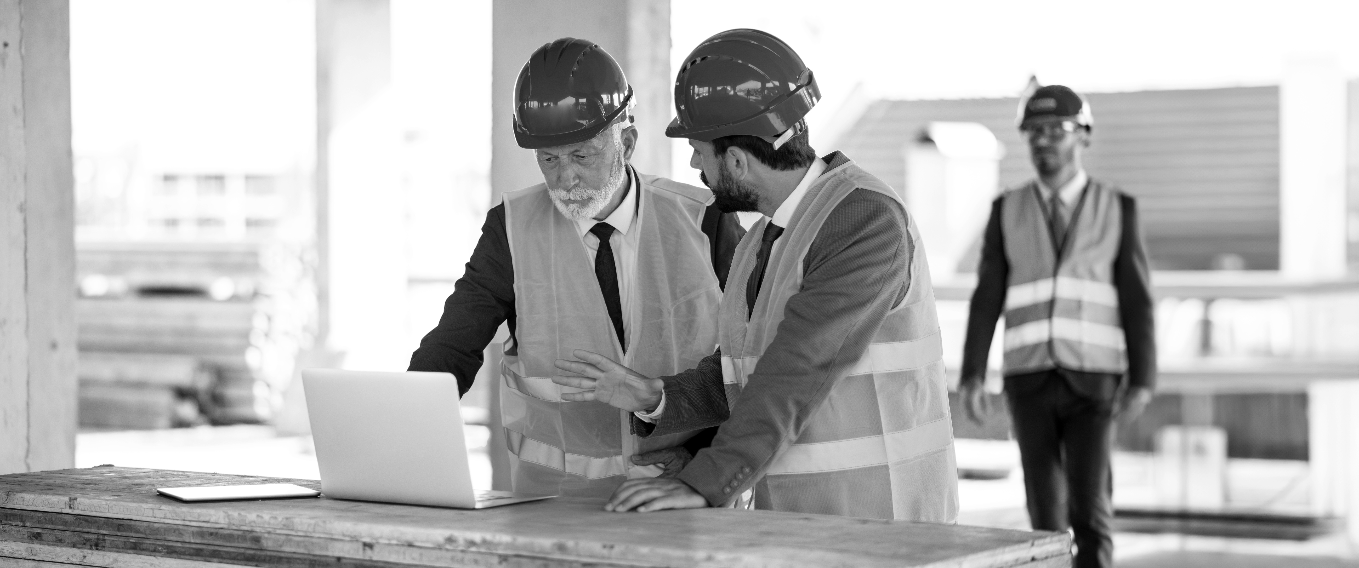 SINGLE-IMAGE_workers-at-construction-site-looking-at-laptop_jan25