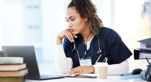 COLOUR-IMAGE_mixed-race-nurse-staring-intently-at-laptop-screen_apr26