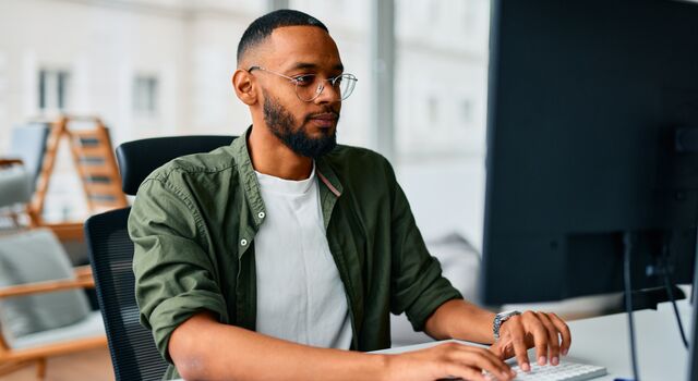 COLOUR-IMAGE_man-with-glasses-working-on-single-screen_jul26
