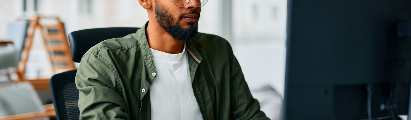 COLOUR-IMAGE_man-with-glasses-working-on-single-screen_jul26