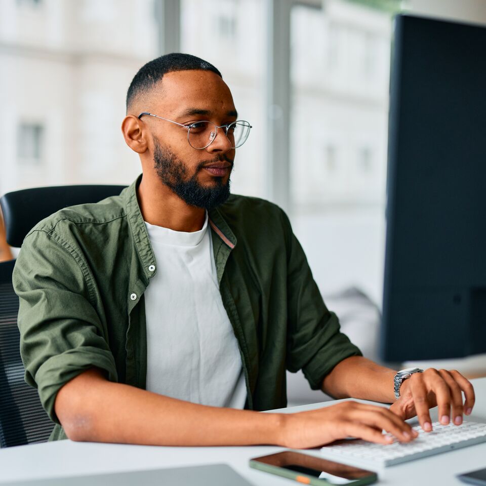 COLOUR-IMAGE_man-with-glasses-working-on-single-screen_jul26