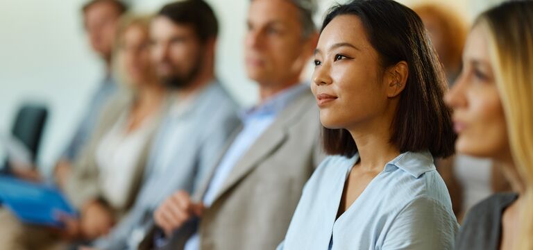 /bynder-asset/bynder:72A46E49-6FA0-411A-8C5C30BA0192B4F5/Landscape_MD/COLOUR-IMAGE_woman-in-conference-audience-smiling-and-engaged_jul26.jpg?1782917096000