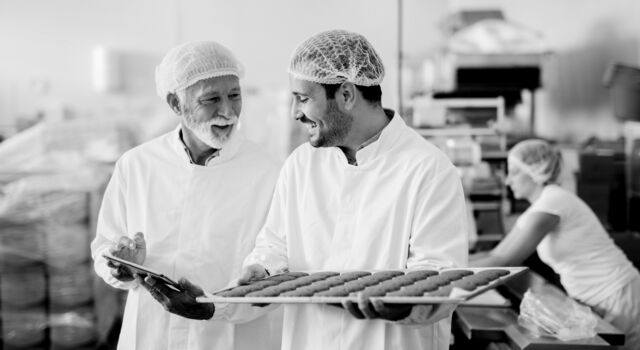 SINGLE-IMAGE_man-with-tablet-checking-tray-of-biscuits_nov23