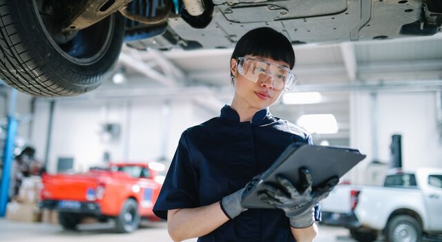 COLOUR-IMAGE_automotive-female-engineer-looking-at-tablet-in-large-industrial-mechanic-workshop_sep26