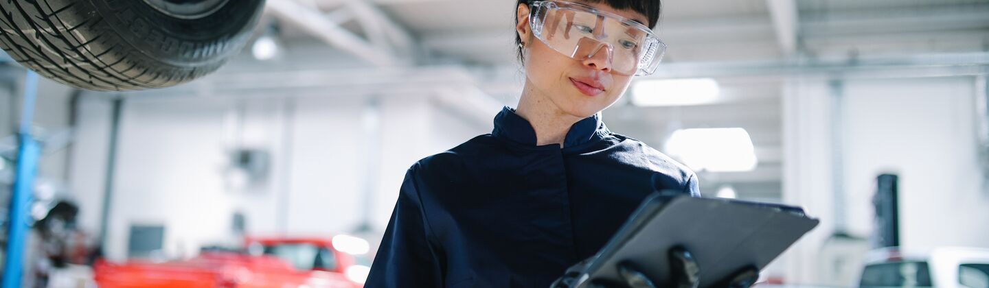 COLOUR-IMAGE_automotive-female-engineer-looking-at-tablet-in-large-industrial-mechanic-workshop_sep26