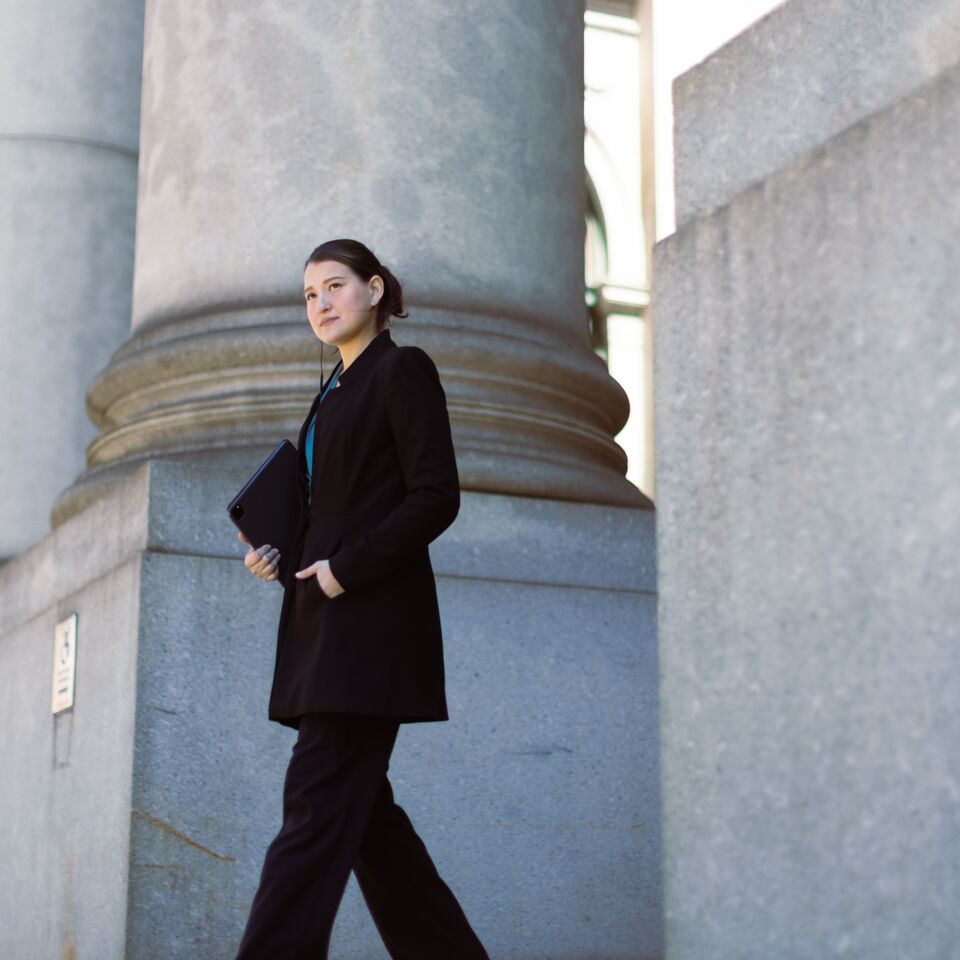COLOUR-IMAGE_woman-walking-out-of-government-building_feb26