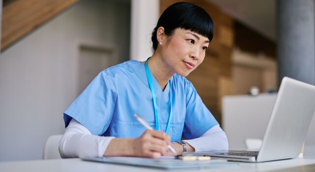 COLOUR-IMAGE_japanese-female-nurse-taking-notes-whilst-looking-at-laptop-screen_apr26