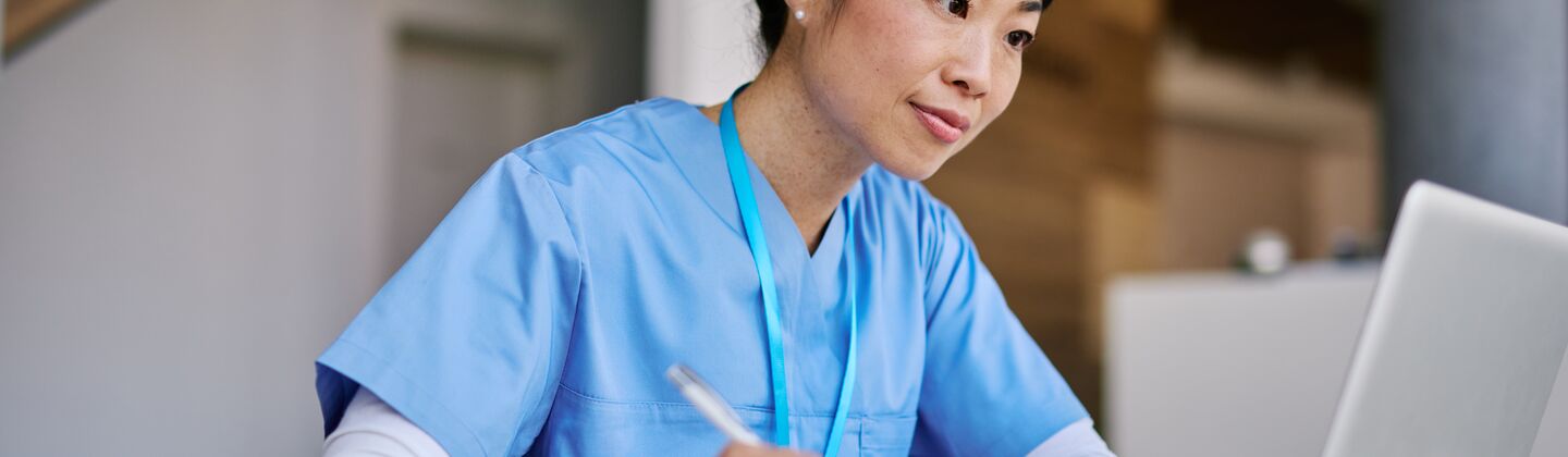 COLOUR-IMAGE_japanese-female-nurse-taking-notes-whilst-looking-at-laptop-screen_apr26