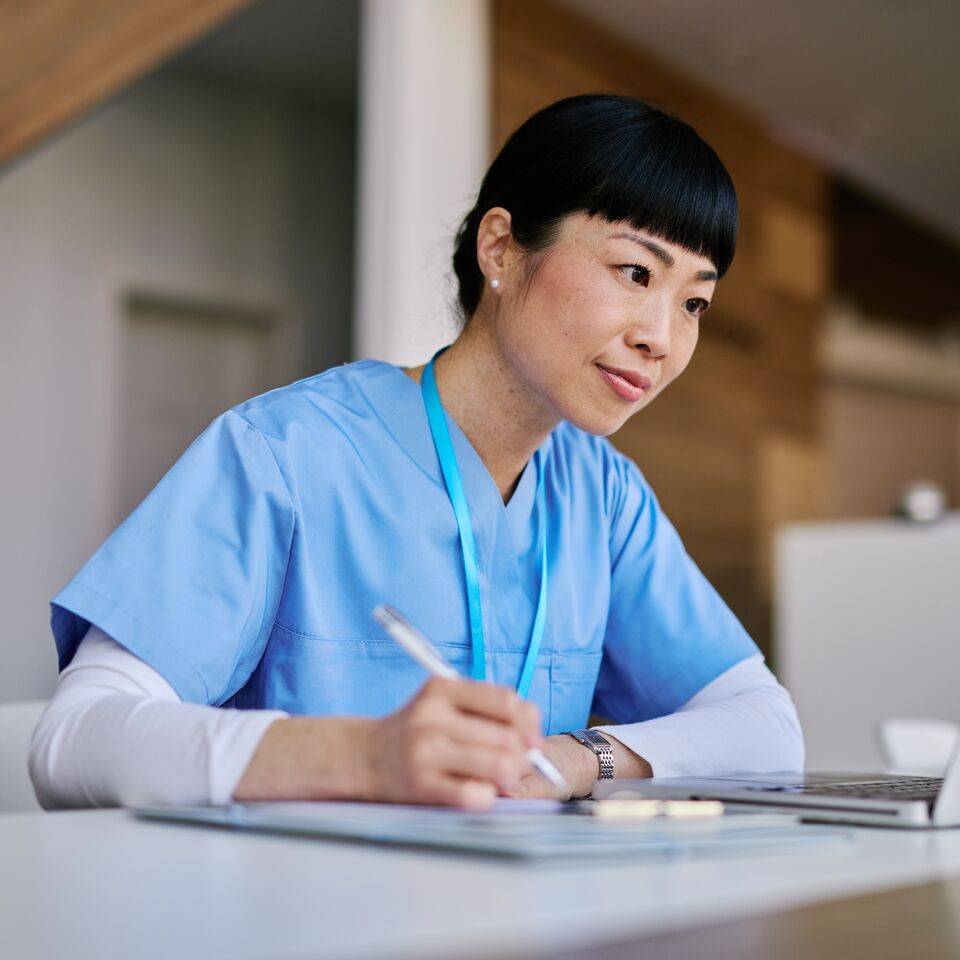 COLOUR-IMAGE_japanese-female-nurse-taking-notes-whilst-looking-at-laptop-screen_apr26
