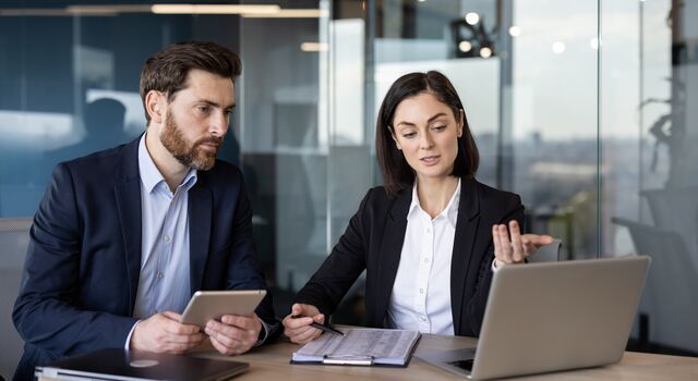COLOUR-IMAGE_man-and-woman-looking-at-laptop-screen-and-discussing_jul26