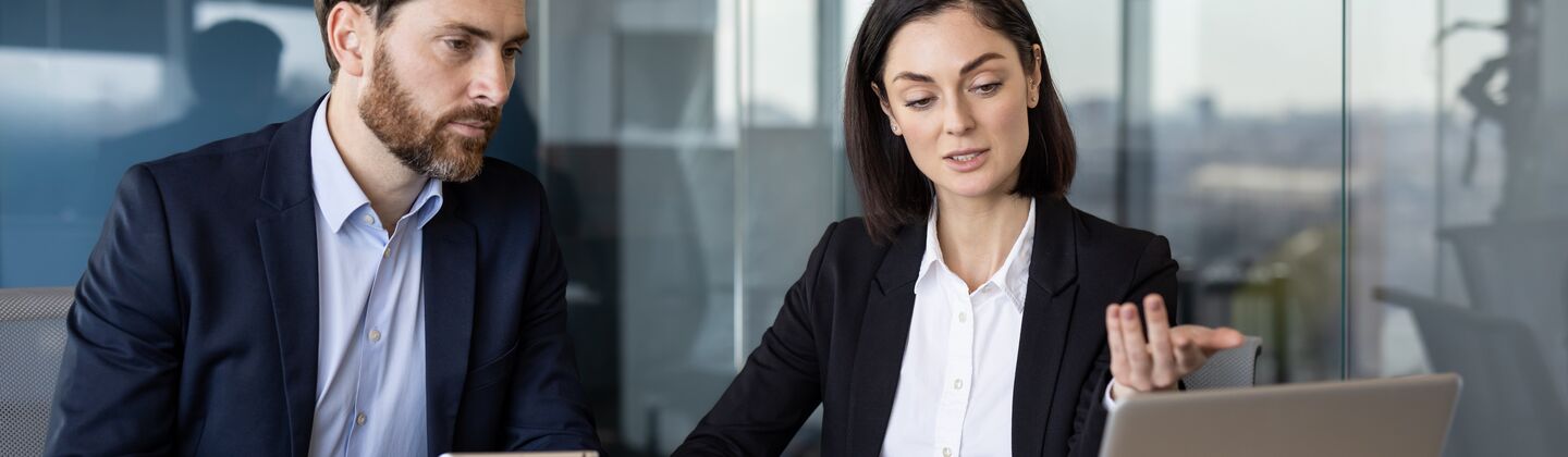 COLOUR-IMAGE_man-and-woman-looking-at-laptop-screen-and-discussing_jul26