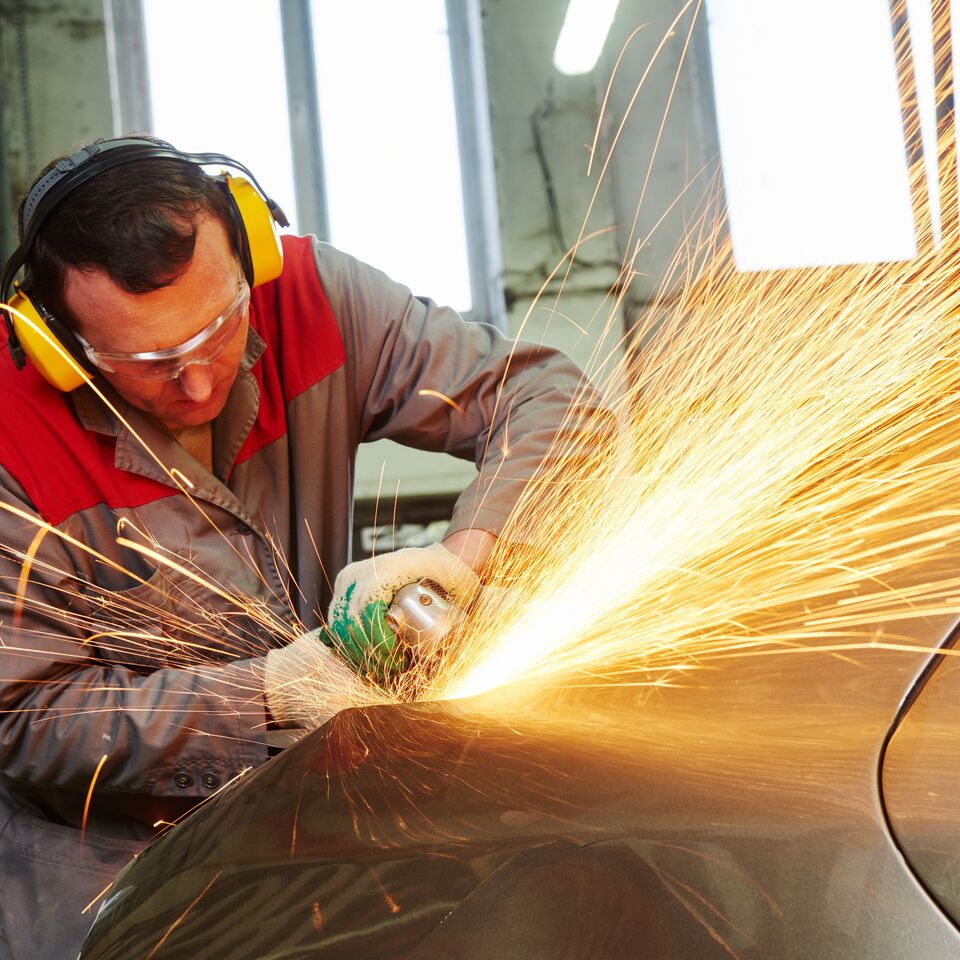 COLOUR-IMAGE_automotive-male-mechanic-using-angle-grinder-on-car-body_feb26