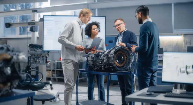 COLOUR-IMAGE_automotive-workers-around-engine-using-laptop_feb26