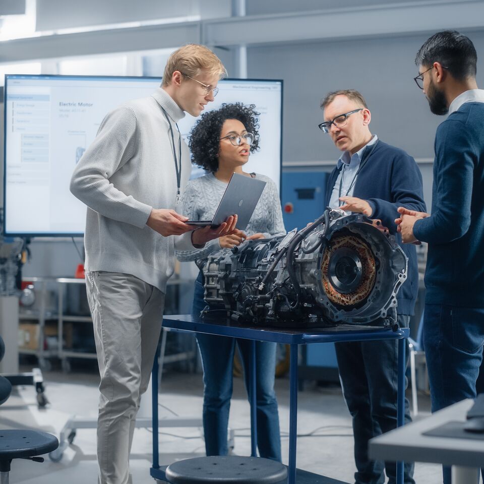 COLOUR-IMAGE_automotive-workers-around-engine-using-laptop_feb26