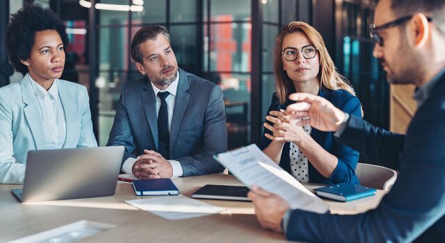 COLOUR-IMAGE_four-professionals-in-business-meeting-seated_jul26