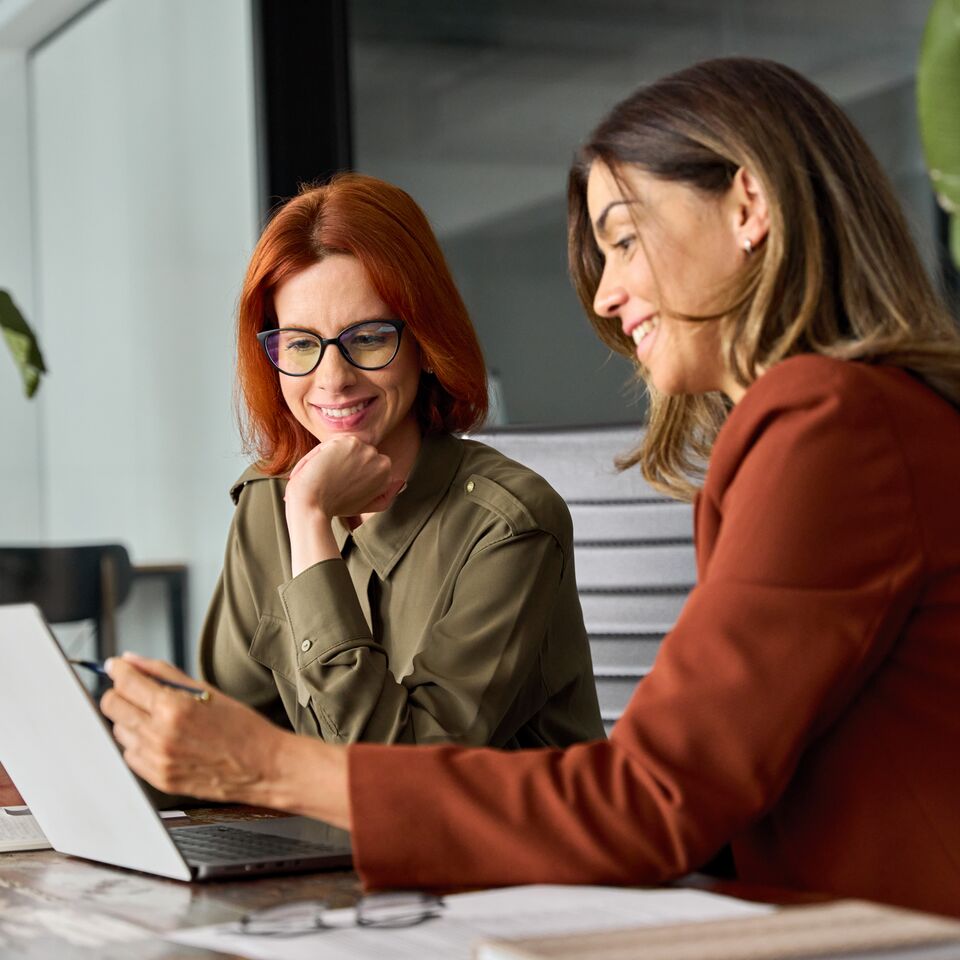 COLOUR-IMAGE_two-women-working-on-laptop-together_jul26