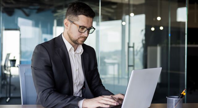 COLOUR-IMAGE_businessman-office-desk-laptop_july26