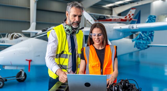 COLOUR-IMAGE_aerospace-man-and-woman-looking-at-laptop-in-hangar-sep26