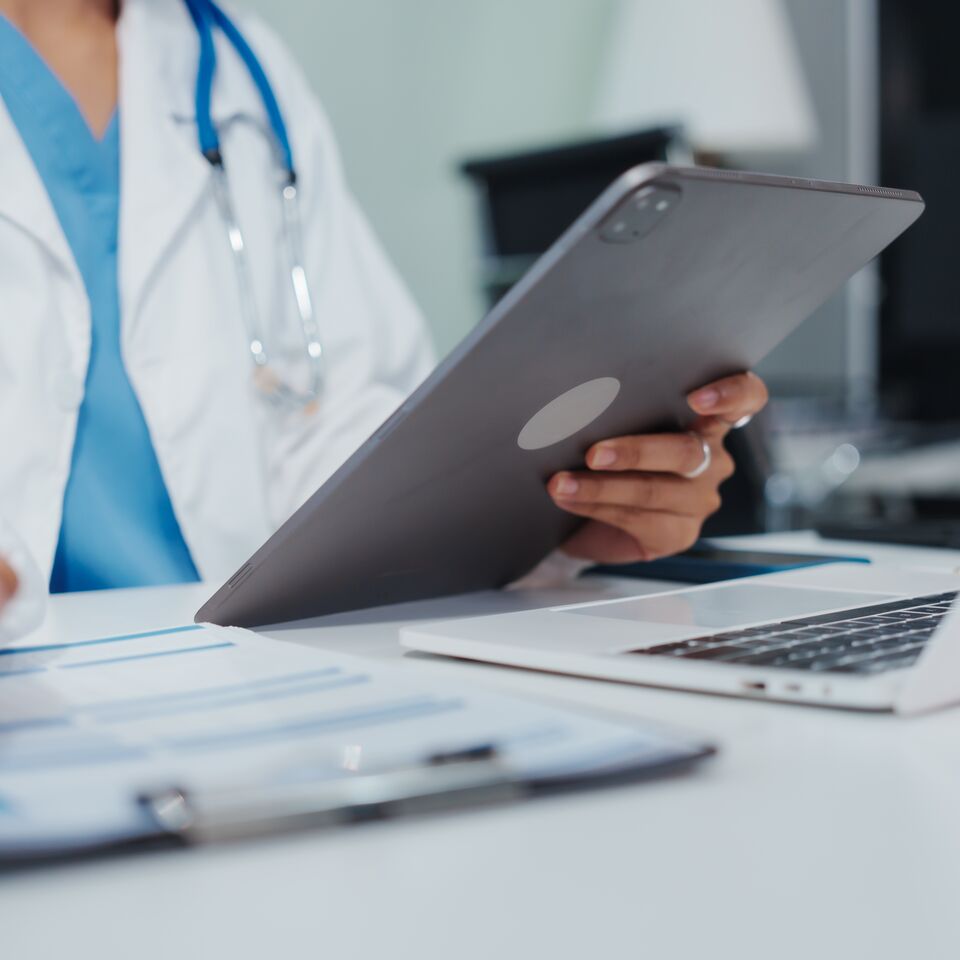 COLOUR-IMAGE_healthcare-doctor-white-coat-tablet-paperwork_feb26