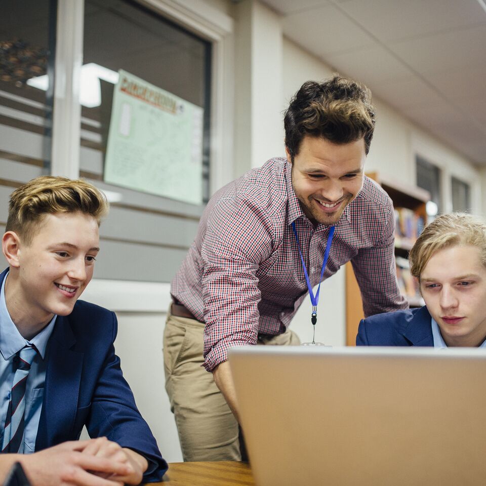COLOUR-IMAGE_male-teacher-supporting-students-smiling_apr26