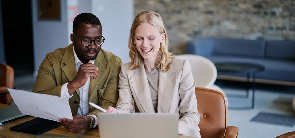 COLOUR-IMAGE_woman-and-man-in-blazers-looking-at-laptop-screen_jul26
