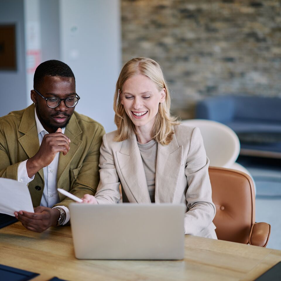 COLOUR-IMAGE_woman-and-man-in-blazers-looking-at-laptop-screen_jul26