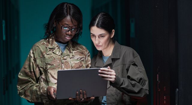 COLOUR-IMAGE_aerospace&defence-female-military-personell-looking-at-laptop-in-data-centre_sep26