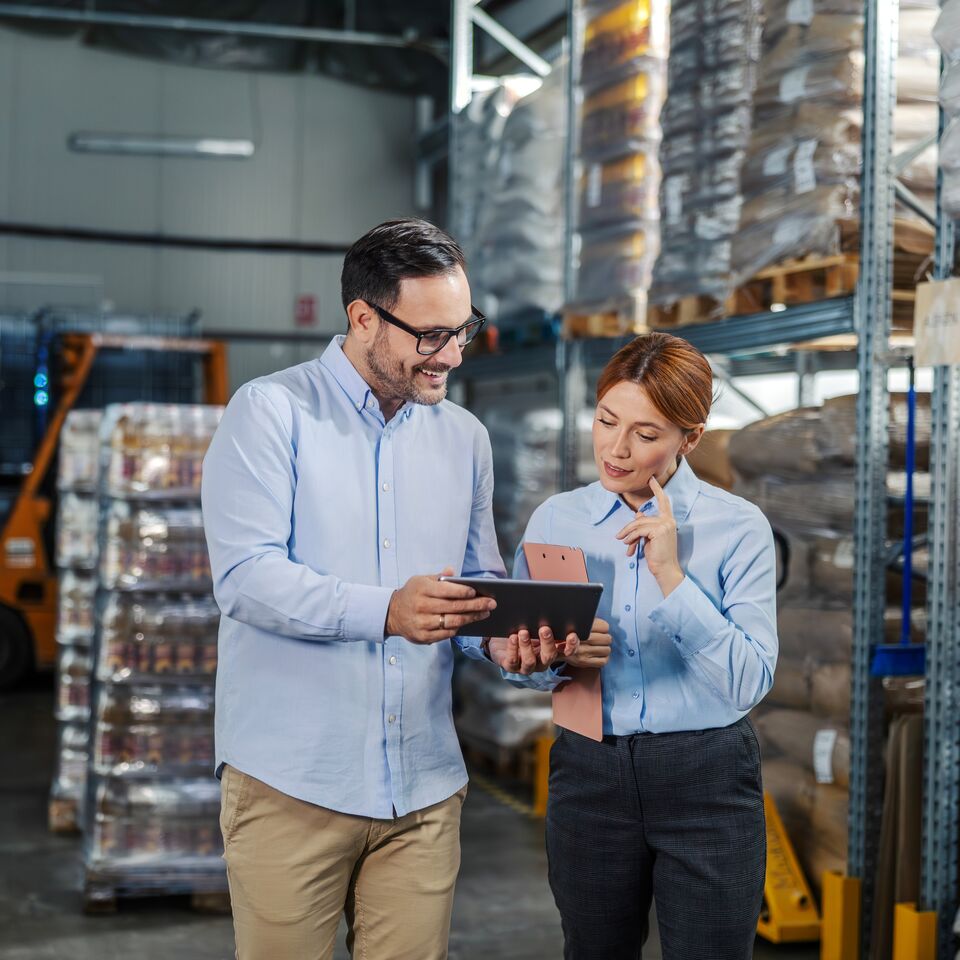 COLOUR-IMAGE_mand-and-woman-talking-over-tablet-in-factory_apr26