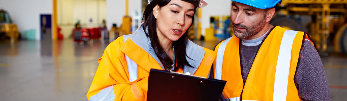 COLOUR-IMAGE_two-colleagues-looking-at-a-clipboard_apr26