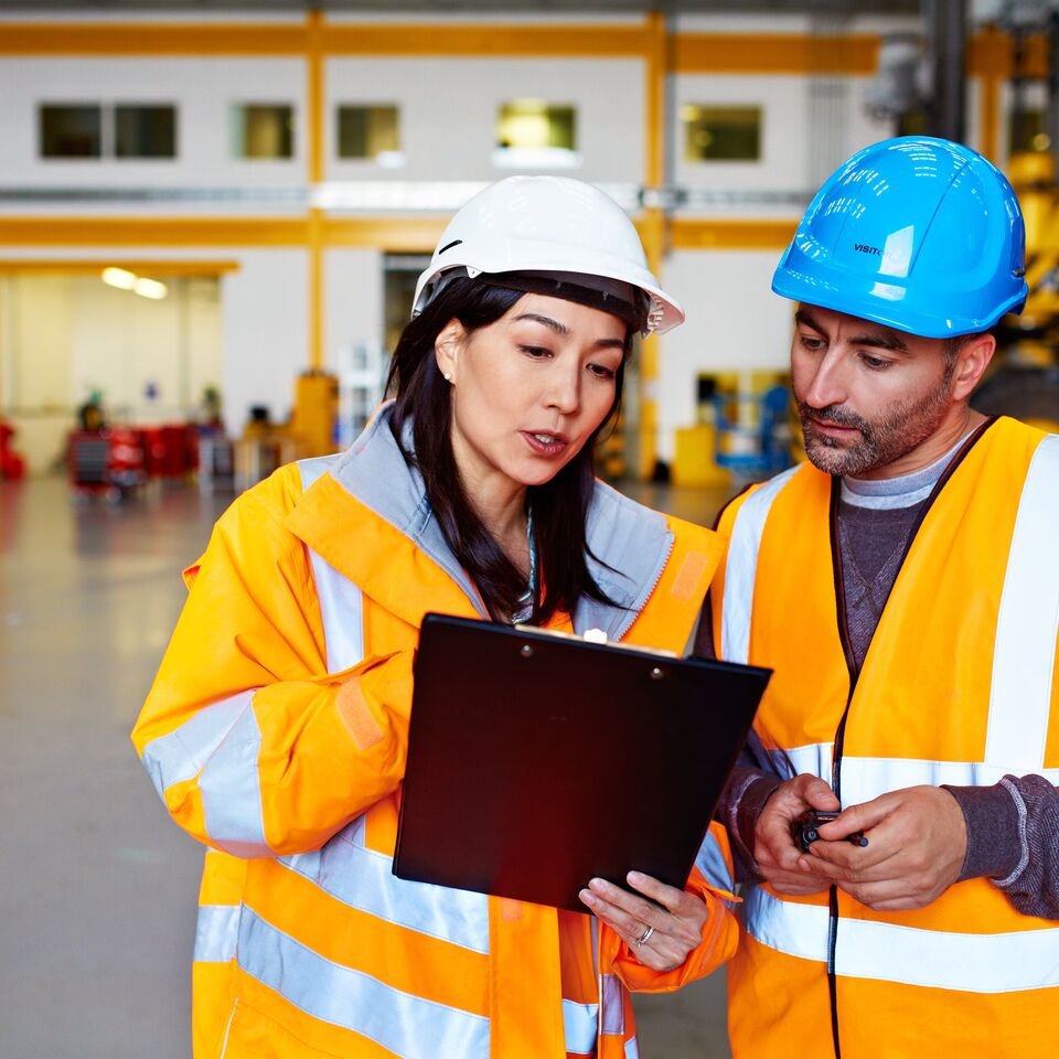 COLOUR-IMAGE_two-colleagues-looking-at-a-clipboard_apr26