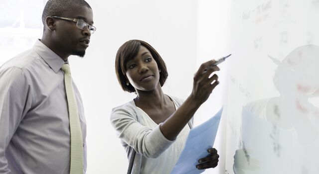 COLOUR-IMAGE_man-and-woman-working-together-on-whiteboard_jul26