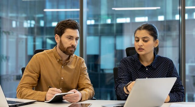 COLOUR-IMAGE_woman-pointing-to-laptop-screen-with-male-colleague_jul26