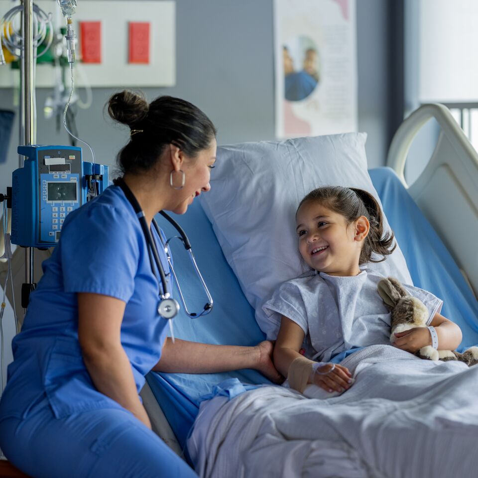 COLOUR-IMAGE_brunette-female-nurse-checking-on-young-female-patient_apr26