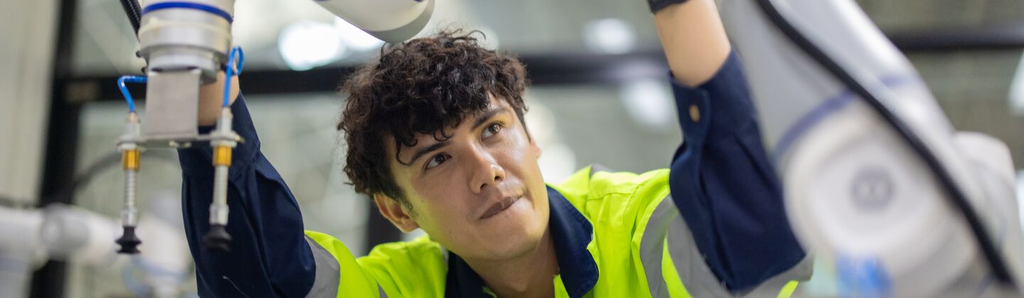 COLOUR-IMAGE_automotive-Male engineer-inspecting-car-manufacturing-robot_feb26