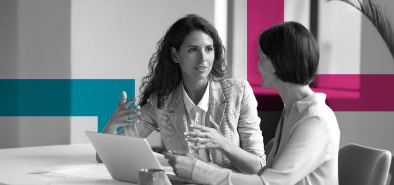/bynder-asset/bynder:EE0BF7BE-326C-45C2-A536F087393C2D40/Landscape_MD/SINGLE-IMAGE_squares-two-business-women-sit-at-desk-laptop_jul24.png?1749636946000