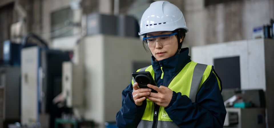 COLOUR-IMAGE_female-worker-EHS-hi-vis-looking-at-mobile-phone_jul26