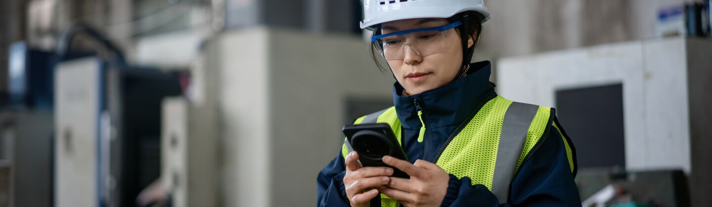 COLOUR-IMAGE_female-worker-EHS-hi-vis-looking-at-mobile-phone_jul26
