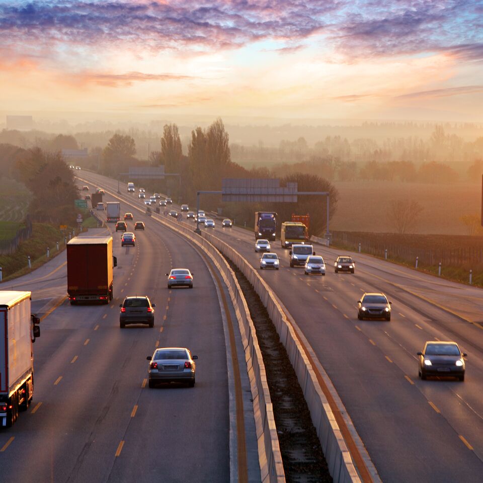 COLOUR-IMAGE_automotive-cars-and-lorries-driving-on-motorway-british-countryside-dusk_feb26