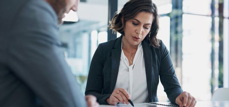COLOUR-IMAGE_woman-holding-pen-pointing-to-document-in-conversation_jul26