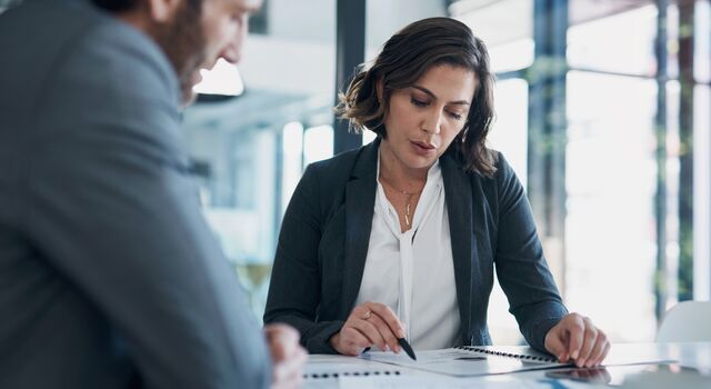 COLOUR-IMAGE_woman-holding-pen-pointing-to-document-in-conversation_jul26