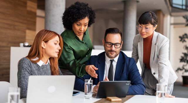 COLOUR-IMAGE_woman-pointing-at-screen-in-group-meeting_jul26